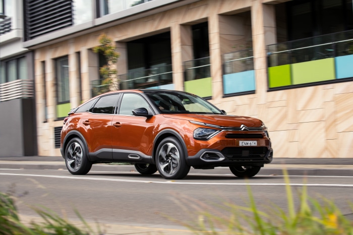 Orange Citroen C4 SUV driving on a street