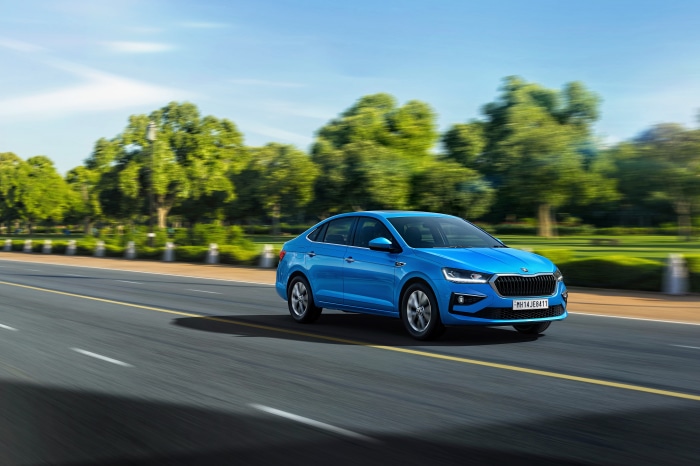 Blue Skoda Slavia driving on a road