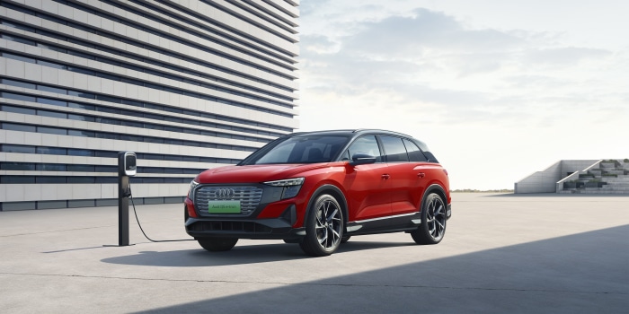 Red Audi Q5 50 E-tron Quattro electric SUV charging