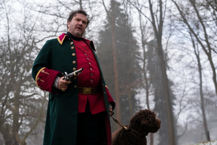 Man in historical costume with pistol and dog