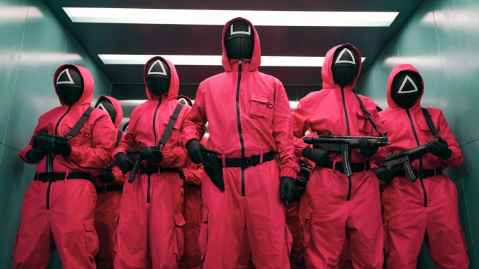 Squid Game guards in pink suits with masks