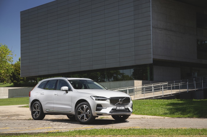 White Volvo XC60 T8 SUV parked near a modern building