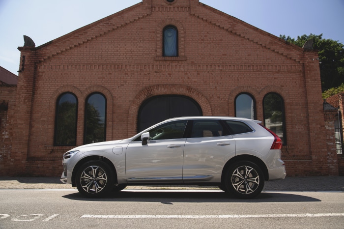 Silver Volvo XC60 T8 SUV parked in front of brick building