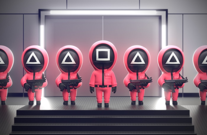 Squid Game guards with guns on stage
