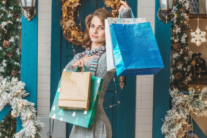 Woman holding shopping bags with Christmas decorations