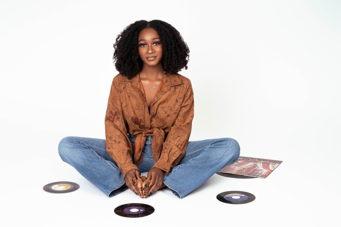 Young Black woman with curly hair and vinyl records