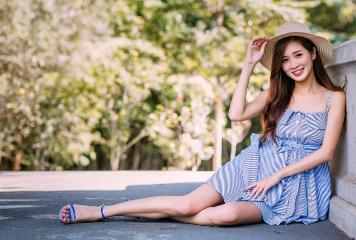 Asian woman in blue dress and hat