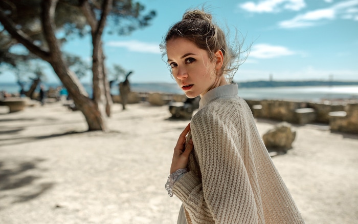 Woman in a knitted cardigan by the water