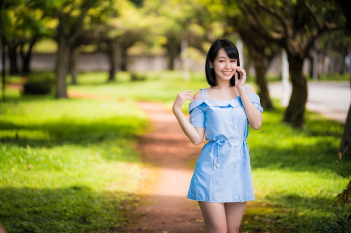 Asian woman in blue dress in park