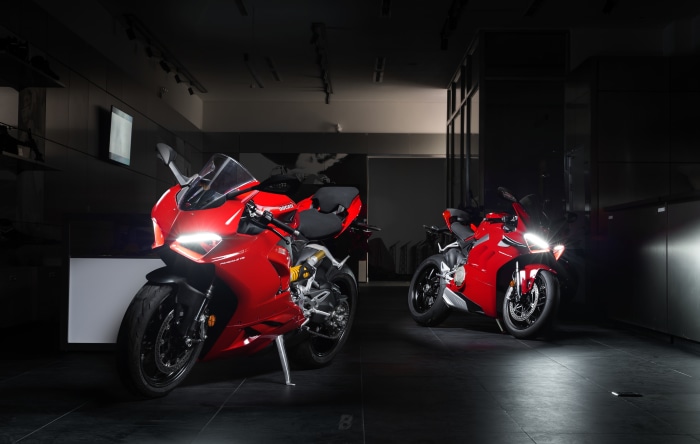 Two red Ducati Panigale V4 motorcycles in a showroom