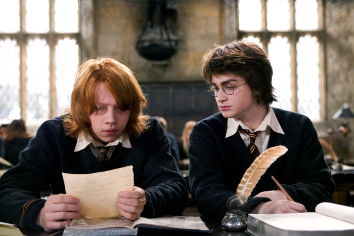 Harry Potter and Ron Weasley studying in a classroom