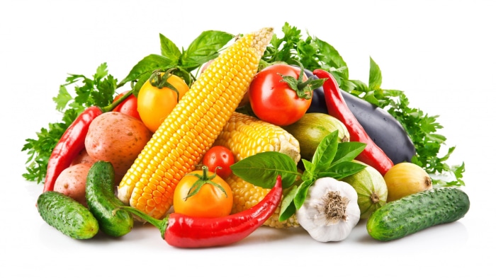 Assortment of fresh vegetables including corn, tomatoes, potatoes, and peppers