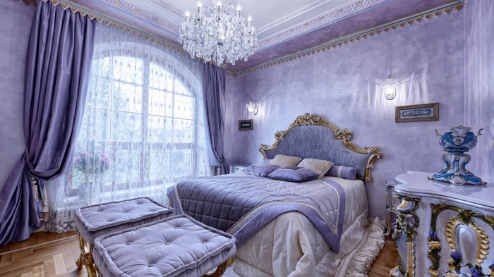Luxurious purple bedroom with ornate furniture
