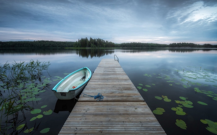 Boat on a wooden dock at a calm lake