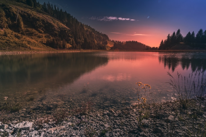 Lake reflecting sunset sky and mountains