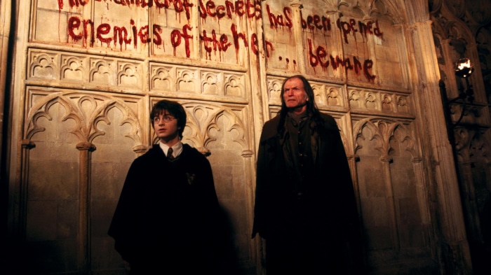 Harry Potter and Argus Filch in front of Chamber of Secrets writing