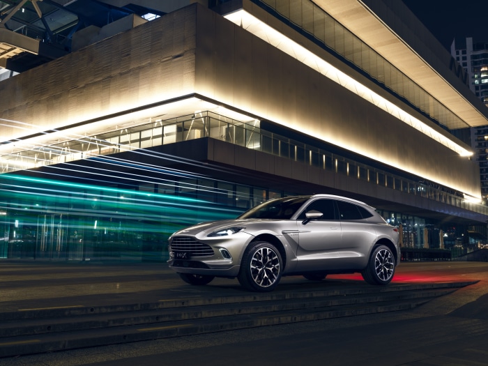 Silver Aston Martin DBX SUV parked at night