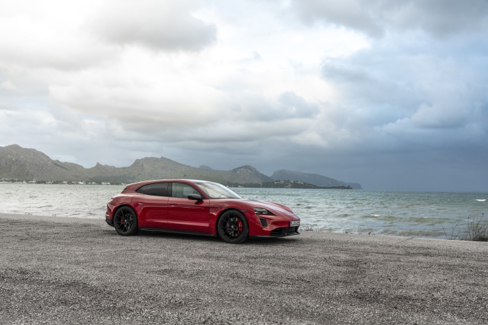 Red Porsche Taycan GTS Sport Turismo by the sea