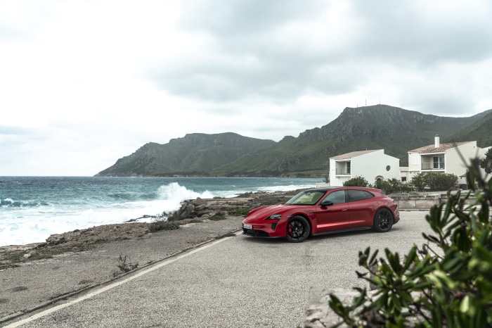 Red Porsche Taycan GTS Sport Turismo on coastal road