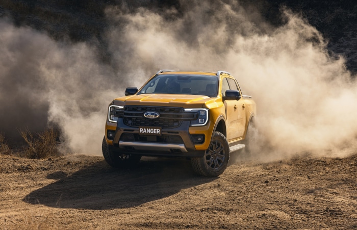Yellow Ford Ranger Wildtrak driving through dust