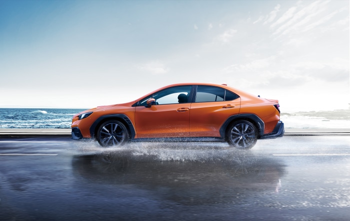 Orange Subaru WRX S4 STI Sport R driving through water