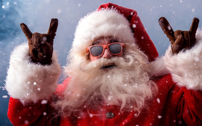 Santa Claus wearing sunglasses and making rock on gesture