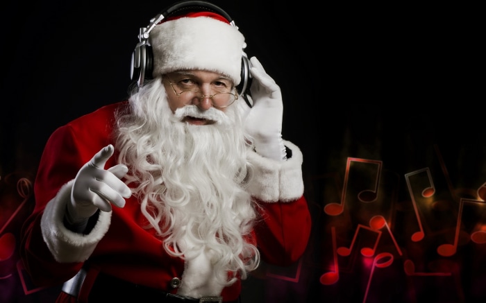 Santa Claus wearing headphones and pointing