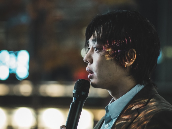 Man speaking into a microphone in Hellbound
