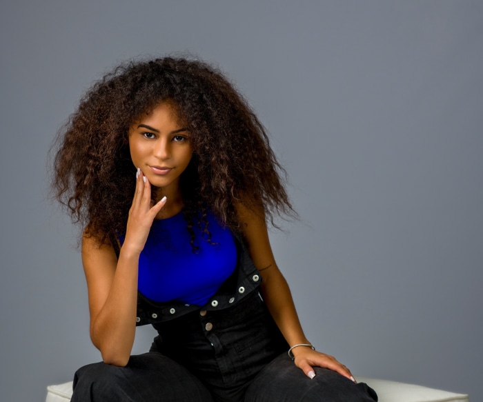 Woman with curly hair wearing overalls