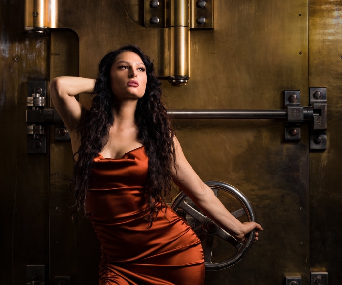 Woman in orange dress by a vault door