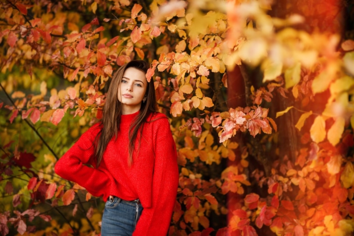 Young woman in red sweater and jeans in autumn