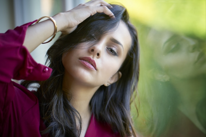 Woman with black hair wearing a maroon top