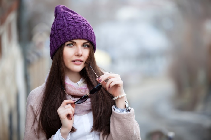Woman wearing a purple knitted hat and sunglasses