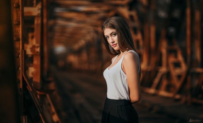 Woman in white tank top and black skirt on a bridge
