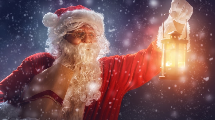 Santa Claus holding a lantern and scroll