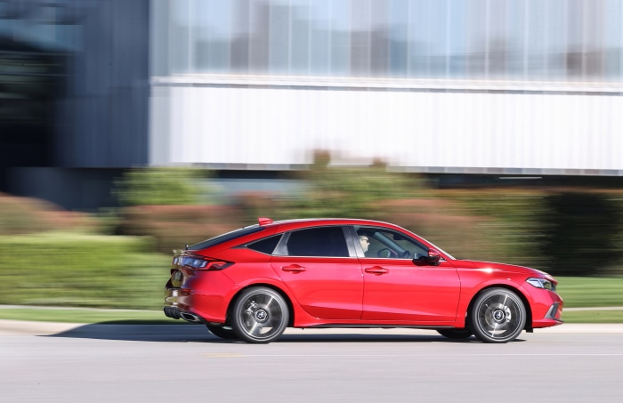 Red Honda Civic Hatchback driving on a road