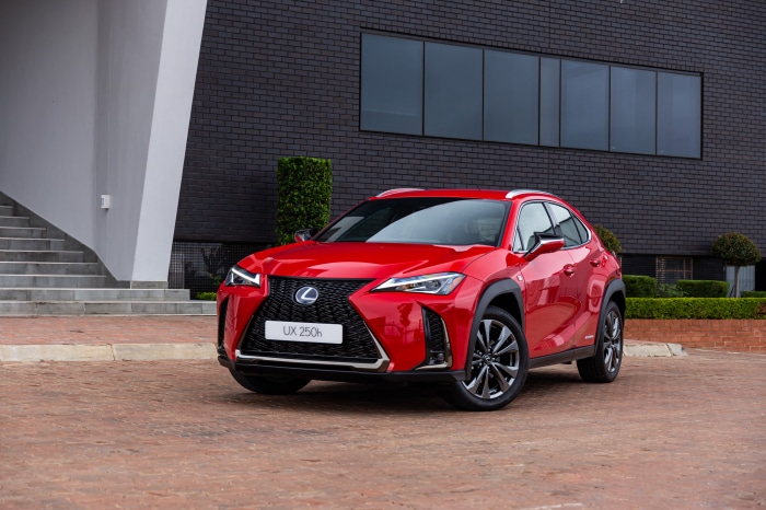 Red Lexus UX 250h F SPORT parked in front of a modern building