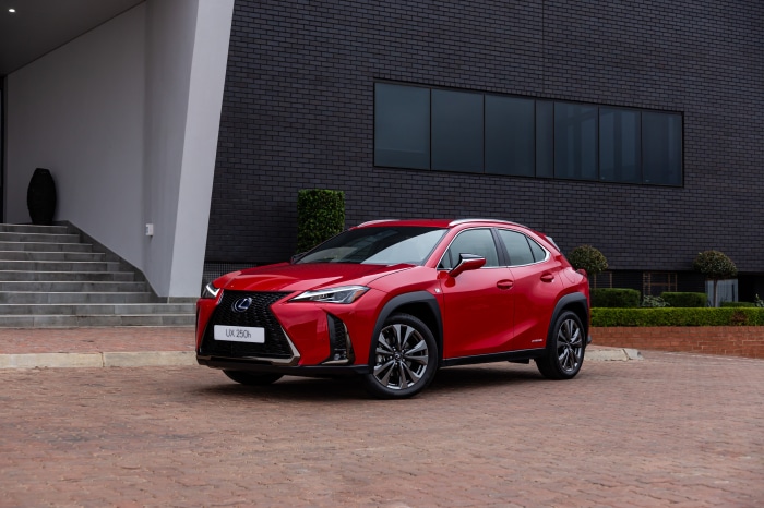Red Lexus UX 250h F SPORT parked outside modern building