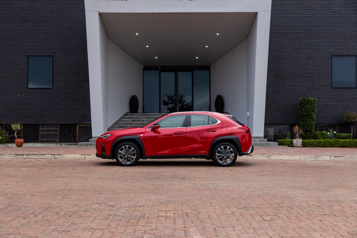 Red Lexus UX 250h F SPORT parked in front of a modern building