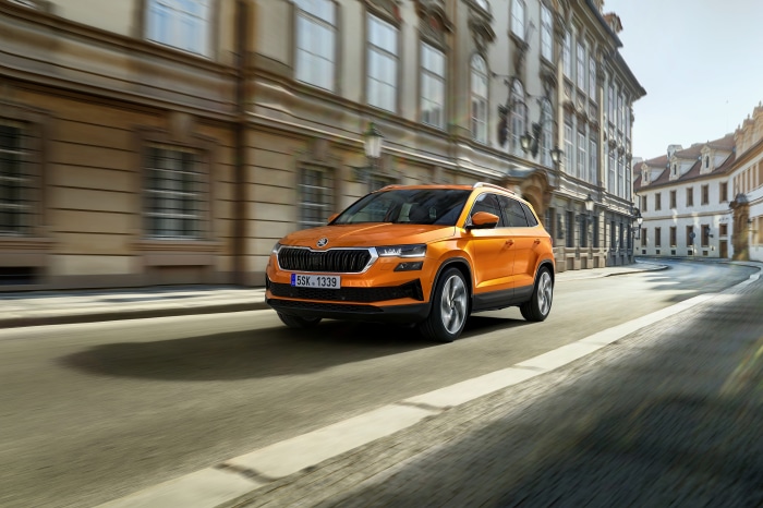 Orange Škoda Karoq SUV driving on a street