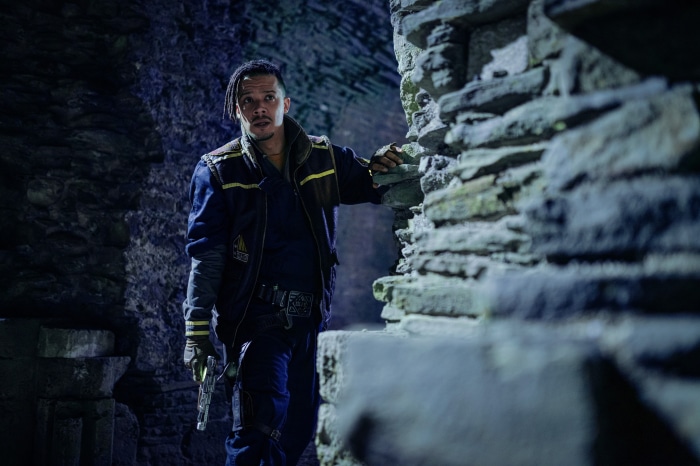 Man with gun in stone ruins