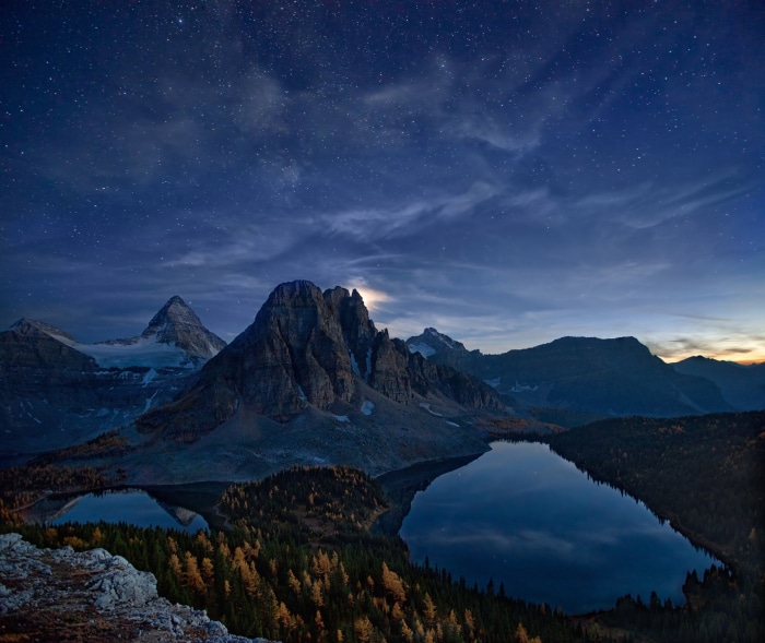 Mountain lake under starry night sky in Canada