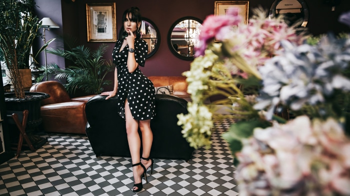 Woman in polka dot dress posing in a lounge