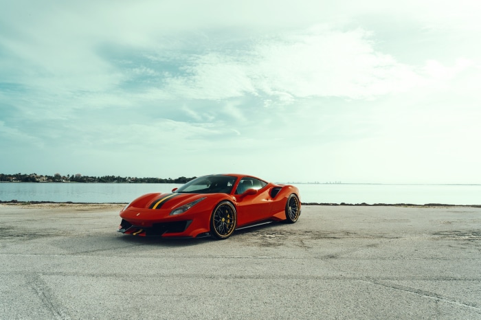 Red Ferrari 488 Pista with racing stripes by the water