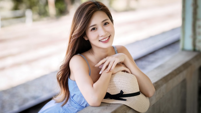 Asian woman with brunette hair wearing a blue dress