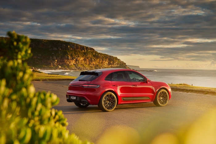 Red Porsche Macan GTS SUV on coastal road