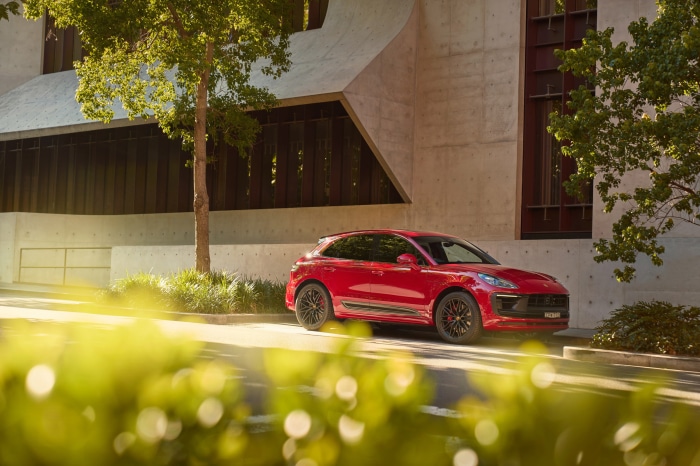 Red Porsche Macan GTS parked near a modern building