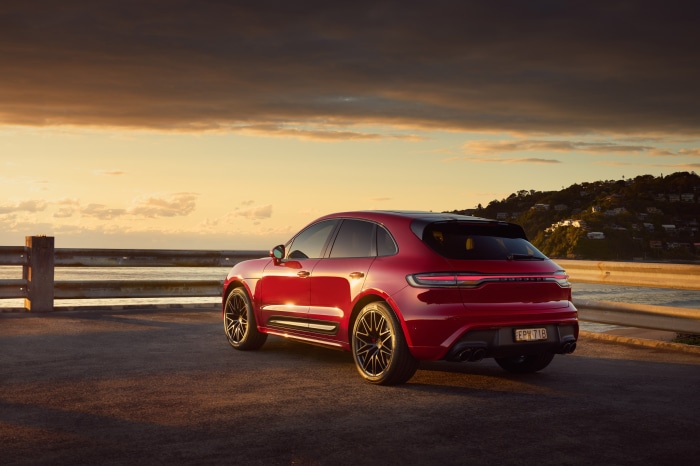 Red Porsche Macan GTS SUV on a road by the sea