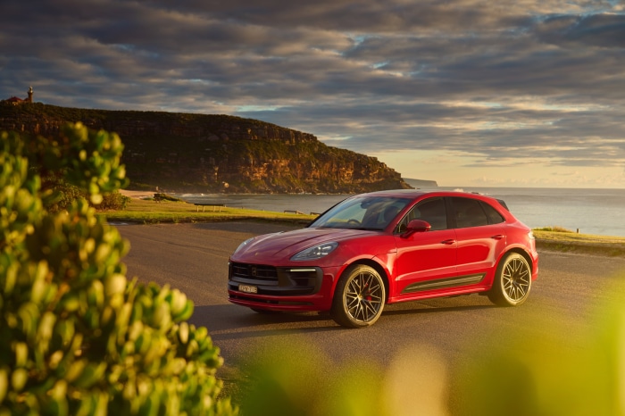 Red Porsche Macan GTS SUV on coastal road