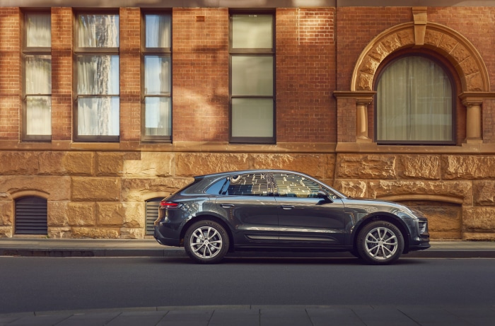 Porsche Macan parked on a street in front of a brick building